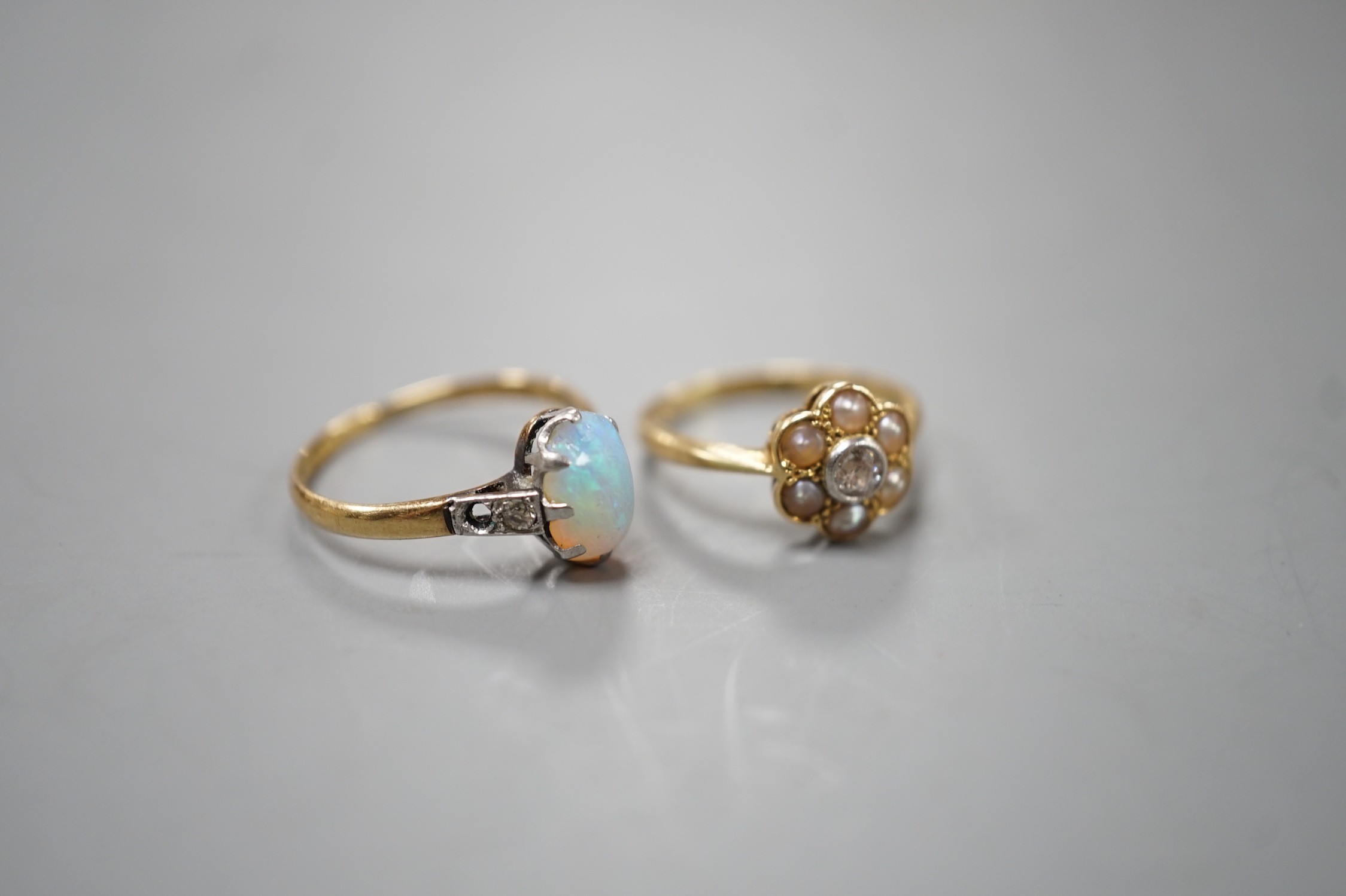 An 18ct and Plat, split pearl and diamond cluster set ring, size F/G and a similar white opal set ring with diamond set shoulders, size L, gross weight 4 grams.